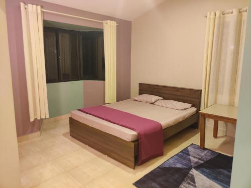 a small bedroom with a bed and a window at Haven Guest House in Kodaikānāl
