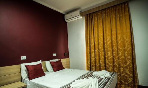 a bedroom with two beds and a curtain at Hotel Euro Suite Poços de Caldas By Nacional Inn in Poços de Caldas