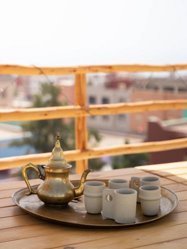 vassoio con bollitore per tè e tazze su un tavolo di Malibu Surf House a Tamraght Ouzdar