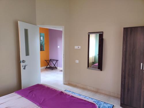 a bedroom with a bed and a mirror on the wall at Haven Guest House in Kodaikānāl