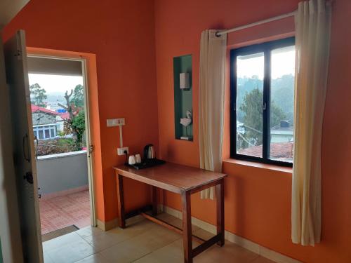 a room with a table and a window at Haven Guest House in Kodaikānāl