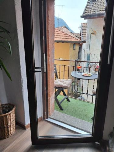 Une porte coulissante en verre s'ouvre sur un balcon avec une table. dans l'établissement Casa dei Pescatori, à Colonno