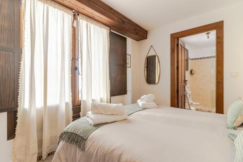 a bedroom with a large white bed and a window at Apartamento San Bartolome Albaicin in Granada