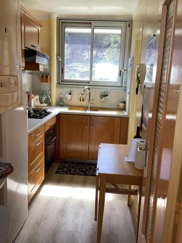 une cuisine avec une table, un évier et une fenêtre dans l'établissement Calme et vue exceptionnelle!, à Banyuls-sur-Mer