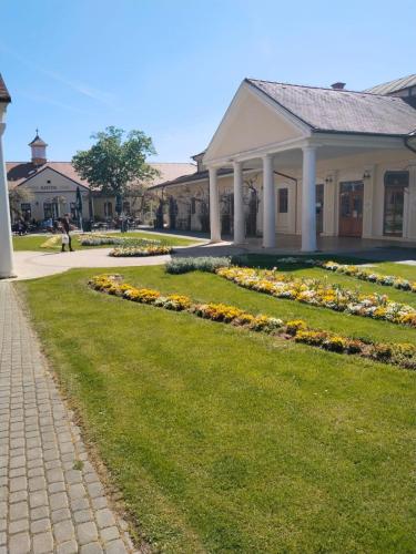 a building with a garden of flowers in front of it at Leier apartments in Piešťany