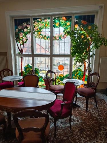 a room with tables and chairs and a large window at Leier apartments in Piešťany