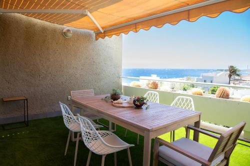 a wooden table and chairs on a balcony with a view at Sea View apartment 2B in Poris de Abona
