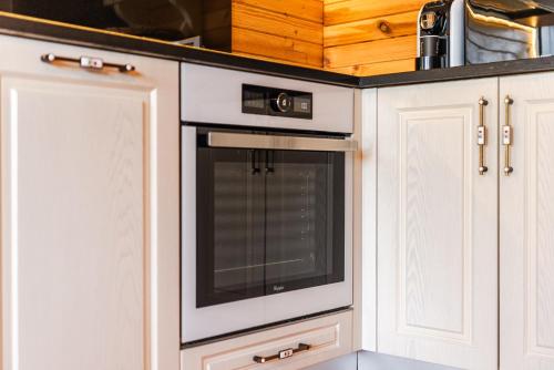 uma cozinha com um forno branco e armários brancos em Villa del Mar San Pietro em Durrës