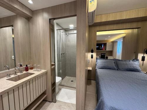 ein Schlafzimmer mit einem Bett und ein Badezimmer mit einer Dusche in der Unterkunft Ap Jardins Pamplona cd 1704 in São Paulo