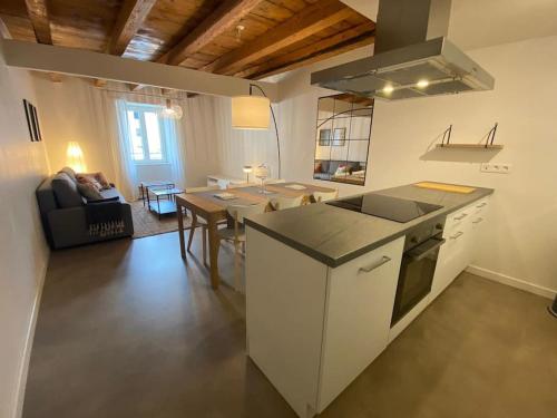 a kitchen and living room with a table and a stove at Sympathique T3 cœur de village in Viuz-en-Sallaz