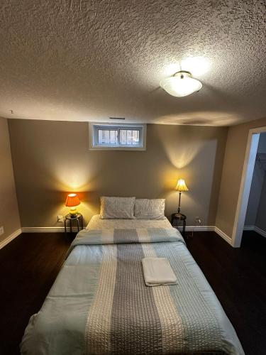 a bed in a bedroom with two lamps and a window at Pocket Friendly Room-Plaza, bus stop walking distance!3 in Kitchener