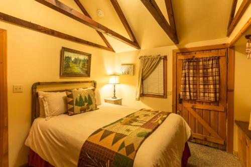 a bedroom with a bed in a room with a window at Arrowhead Pine Rose Cabins in Twin Peaks