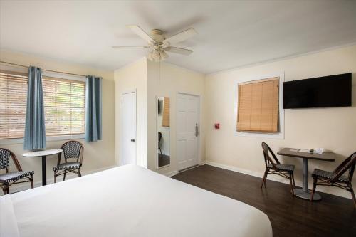 a bedroom with a bed and a table and chairs at Southernmost Inn Adult Exclusive in Key West