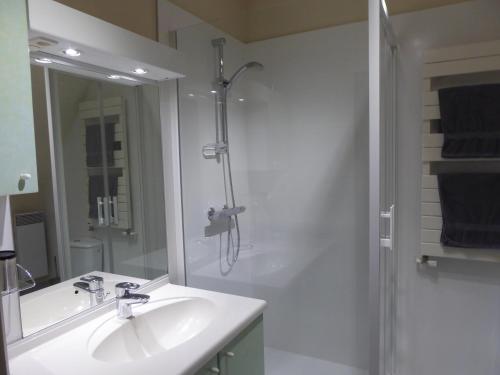 a white bathroom with a sink and a shower at Le Clos du Pont Martin in Saint-Briac-sur-Mer