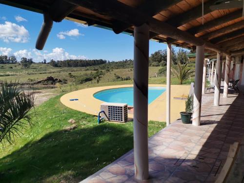 uma vista para uma piscina a partir do alpendre de uma casa em La casa del Lago em Pan de Azúcar