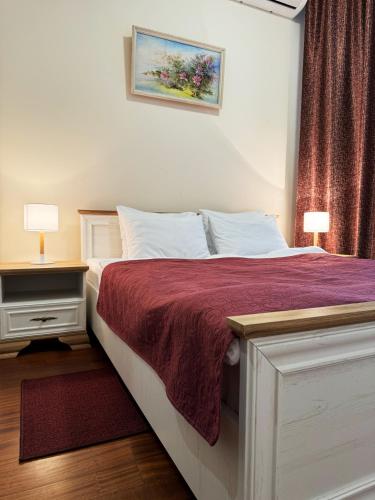 a bedroom with a white bed with a red blanket at SIGNEEV'S Villa in Kyiv