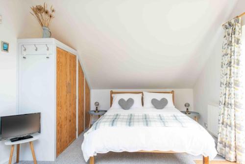 Un dormitorio con una cama y un televisor. en A cosy hideaway on the Jurassic Coast, en Lyme Regis