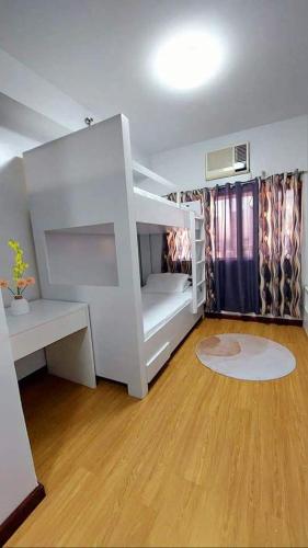 białe łóżko piętrowe w pokoju z drewnianą podłogą w obiekcie Casa Crespo w mieście Manila