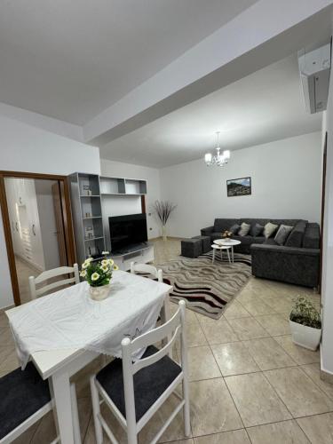 uma sala de estar com uma mesa e um sofá em Idili Historik i Kodrës em Berat