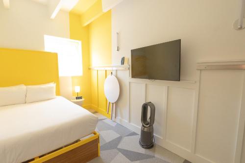 a bedroom with a bed and a flat screen tv at The Gallatin in Nashville