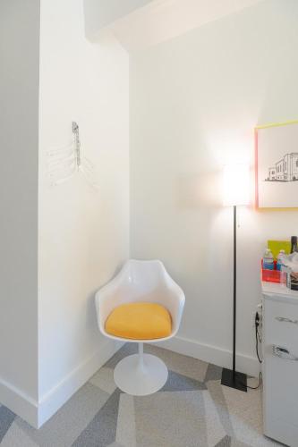 a white chair with an orange seat in a room at The Gallatin in Nashville