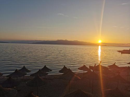 a group of umbrellas on a beach at sunset at oasis apartment in Sarandë