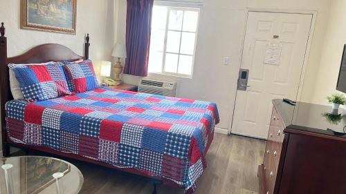 a bedroom with a bed and a window and a door at Economy Inn Paso Robles in Paso Robles