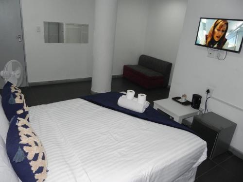 a bedroom with a bed with two towels on it at De Bliss Lodge in Johannesburg