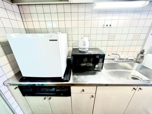 a kitchen with a microwave and a sink at Purezant - Vacation STAY 37459v in Orio