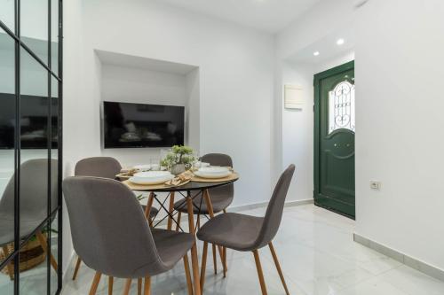 a dining room with a table and chairs and a green door at Lusso di Campiello in Corfu Town