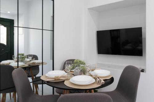 a dining room with a table with chairs and a tv at Lusso di Campiello in Corfu Town