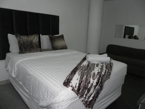 a bedroom with a large bed with a black headboard at De Bliss Lodge in Johannesburg