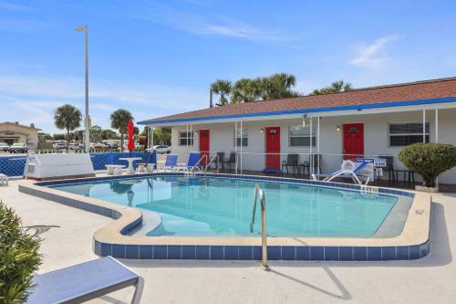 una piscina in un resort con sedie e un edificio di Sun Island Motel a St Pete Beach