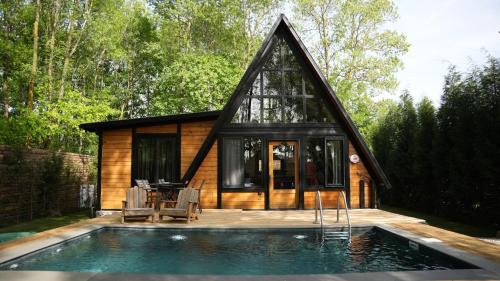 une petite maison avec une piscine en face de celle-ci dans l'établissement Pentalow Cabin, à Kocaeli