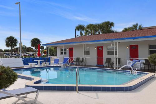 a swimming pool with chairs and a building at Sun Island Motel in St. Pete Beach
