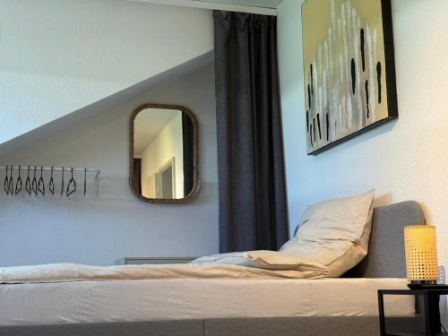 1 dormitorio con cama y espejo en la pared en Wohnen in der Natur, en Saarbrücken