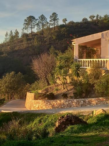a building with a road next to a mountain at Charming house in Alte with pool in Alte