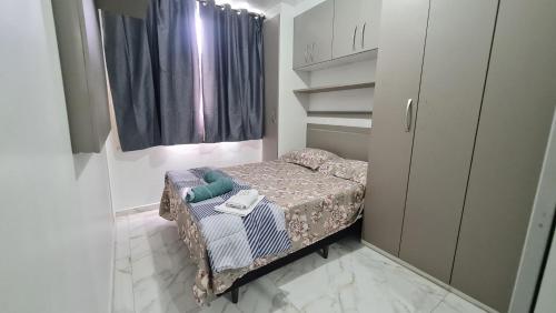 ein kleines Schlafzimmer mit einem kleinen Bett in einem Zimmer in der Unterkunft Apartamento 2 Quartos Condomínio Clube 2 Vagas Garagem in Curitiba