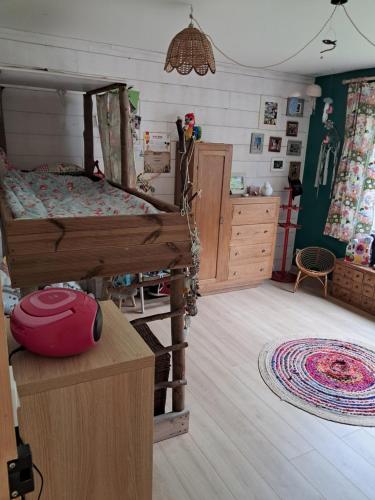 1 dormitorio con 1 cama y suelo de madera en La maison des sources, en Hérouville-Saint-Clair