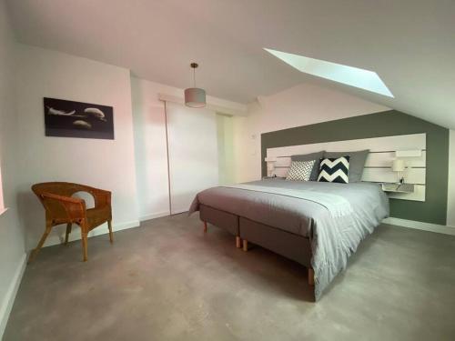ein Schlafzimmer mit einem großen Bett und einem Stuhl in der Unterkunft T2 paisible en cœur de village in Viuz-en-Sallaz