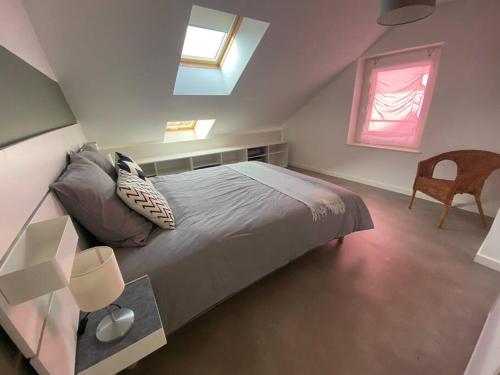 ein Schlafzimmer mit einem Bett, einem Stuhl und einem Fenster in der Unterkunft T2 paisible en cœur de village in Viuz-en-Sallaz