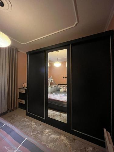 een kamer met een grote glazen deur en een slaapkamer. bij Reka Apartment in Tirana
