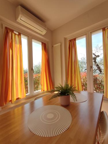 a dining room with a wooden table and windows at Nice apartments lake view & free parking in Pastrengo