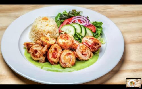 a plate of food with shrimp and vegetables on a table at Hotel Maioris El Diez Culiacan in Culiacán