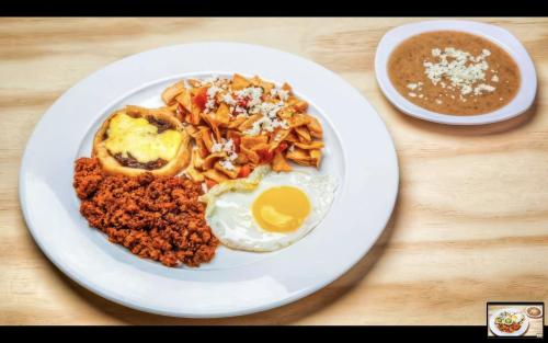 a plate of food with an egg on a table at Hotel Maioris El Diez Culiacan in Culiacán