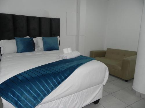 a bedroom with a large bed and a couch at De Bliss Lodge in Johannesburg