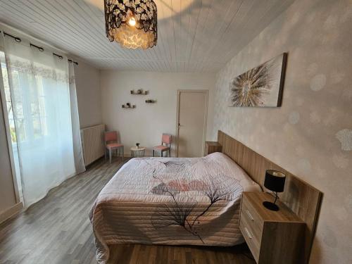 une chambre avec un lit et un lustre dans l'établissement Maison périgourdine au calme, à Grèzes