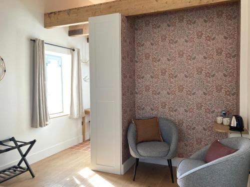 uma sala de estar com duas cadeiras e uma janela em Maison Chemin, chambres d'hôtes à Amboise em Amboise