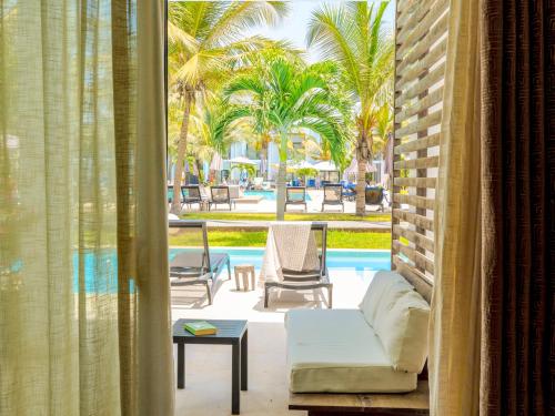 a living room with a couch and a view of a pool at Tamala Beach Resort in Kotu