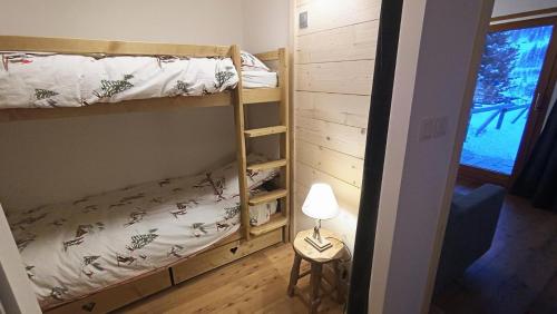 une chambre avec deux lits superposés et une lampe dans l'établissement Résidence Alpages Bellevue - Superbe studio au calme, avec jardin et vue magnifique MAE-5241, à Montgenèvre
